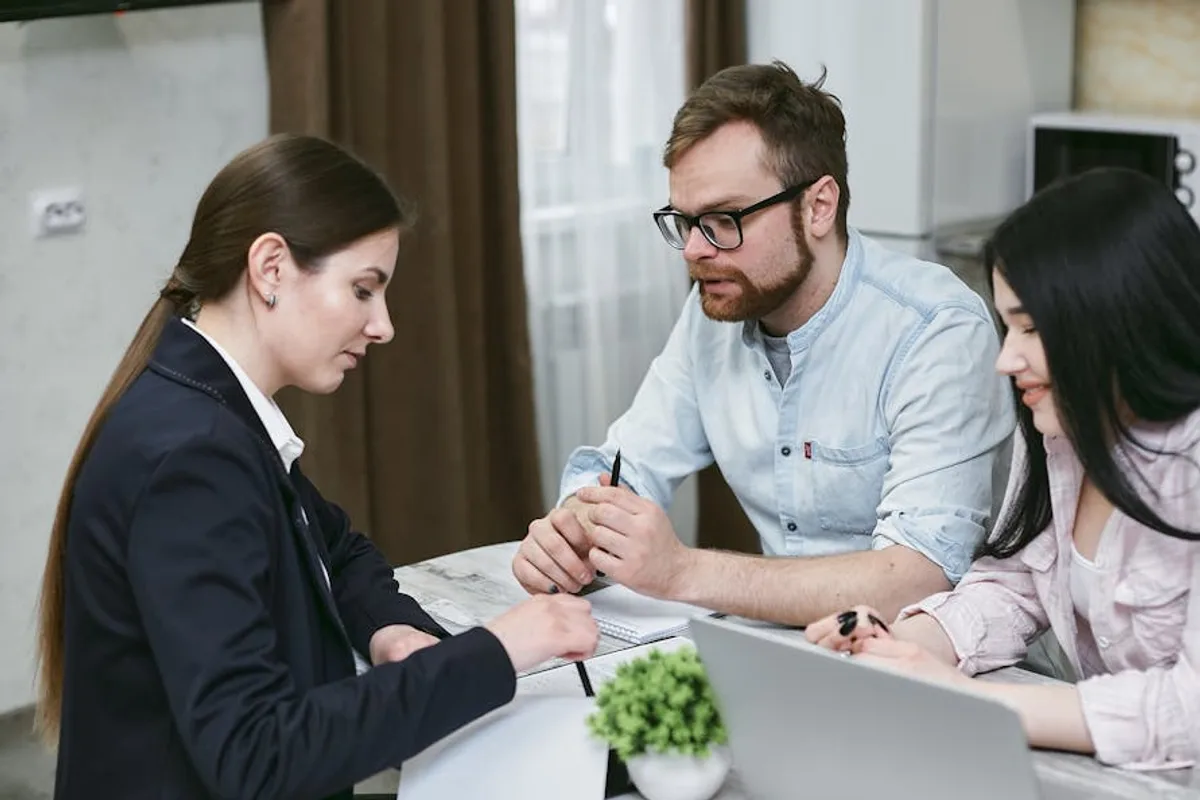 A couple discusses financial documents with their advisor, highlighting investment strategies.