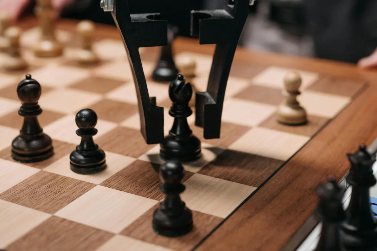 Futuristic AI robot arm making chess move during a game with a human player.
