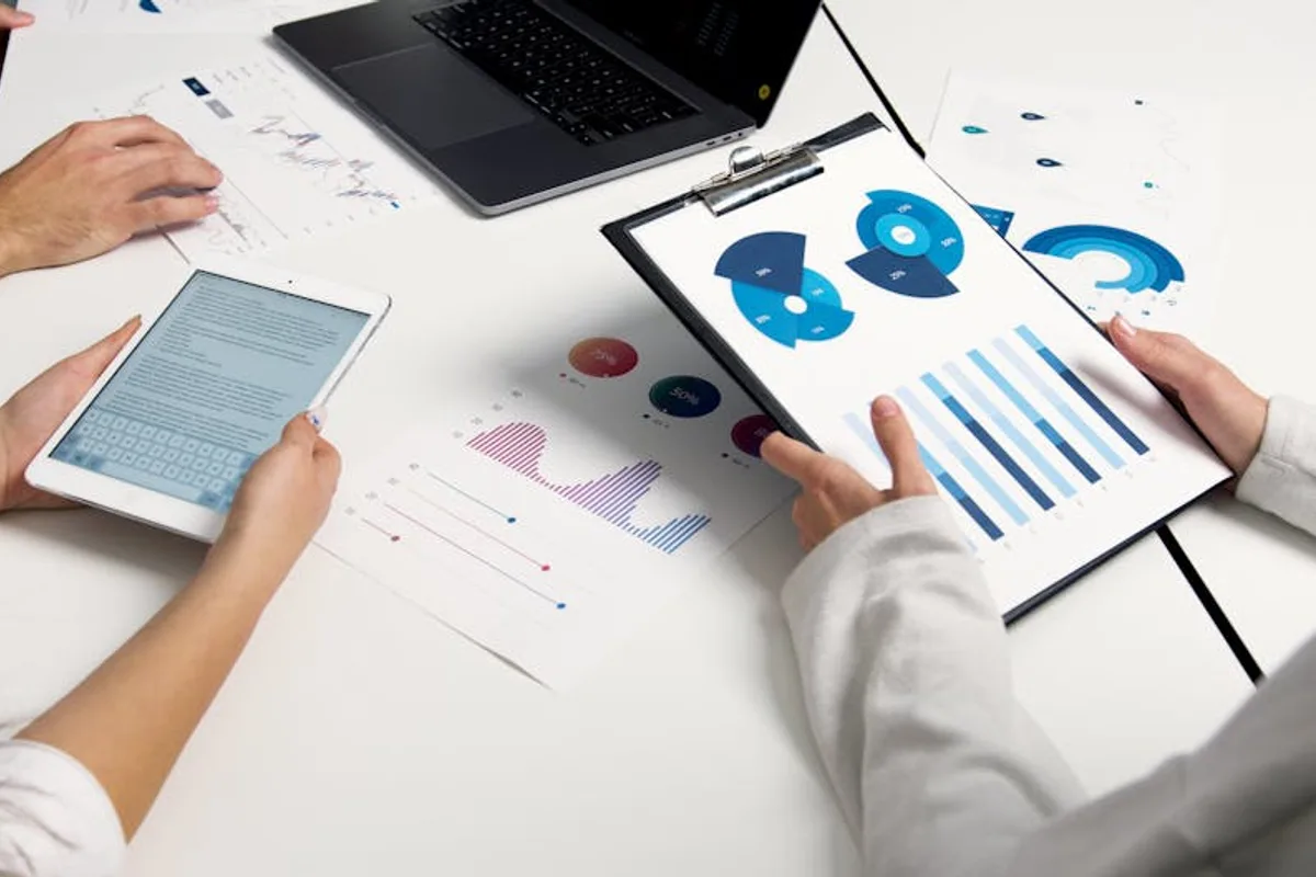 Team analyzing financial charts and digital reports during a business meeting.