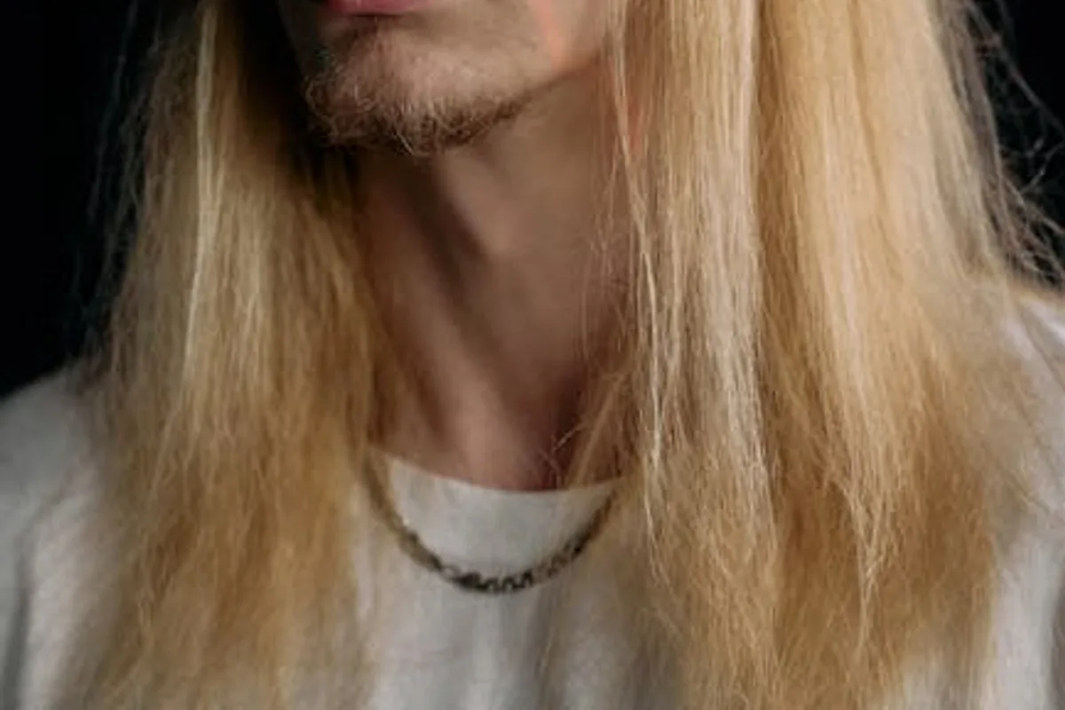 Studio portrait of a man illuminated by laser lines against a black background.
