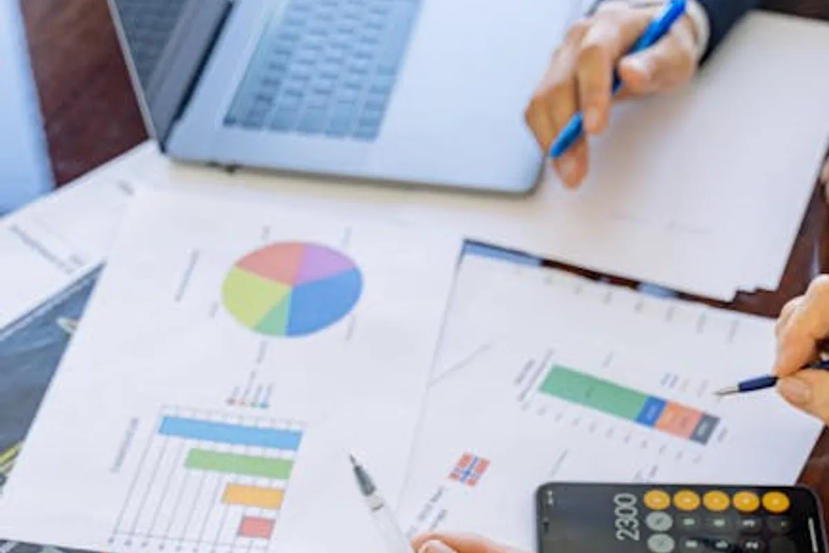 A close-up of businesspeople analyzing financial data and charts during a meeting.
