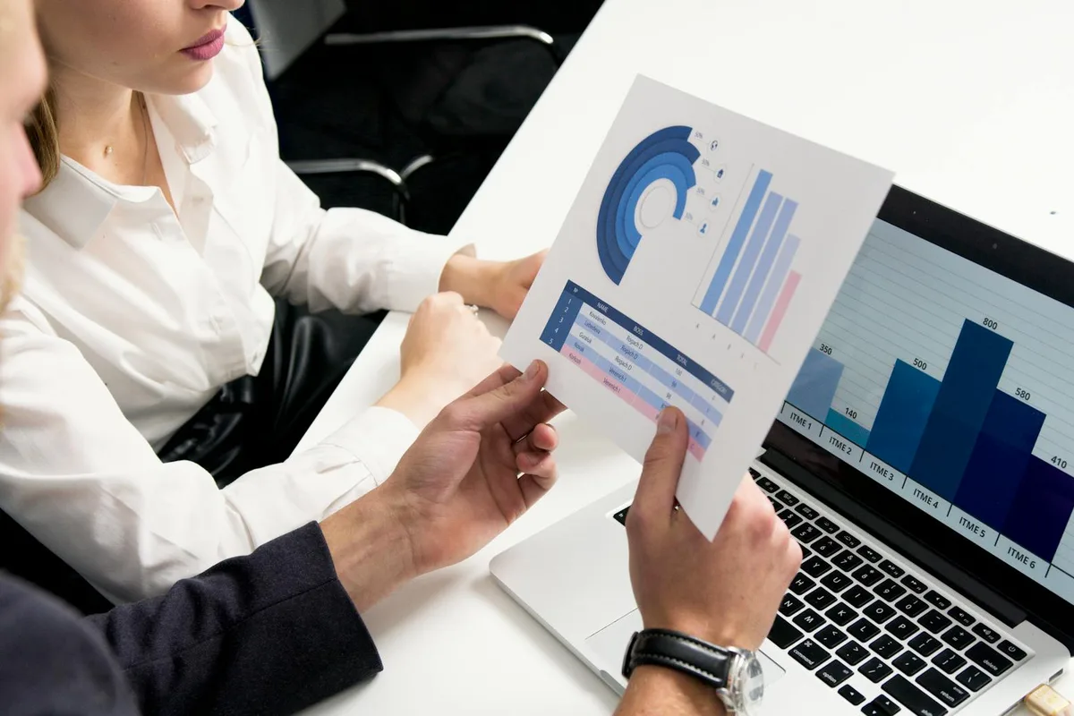 Business professionals discussing data charts and graphs in a modern office setting.